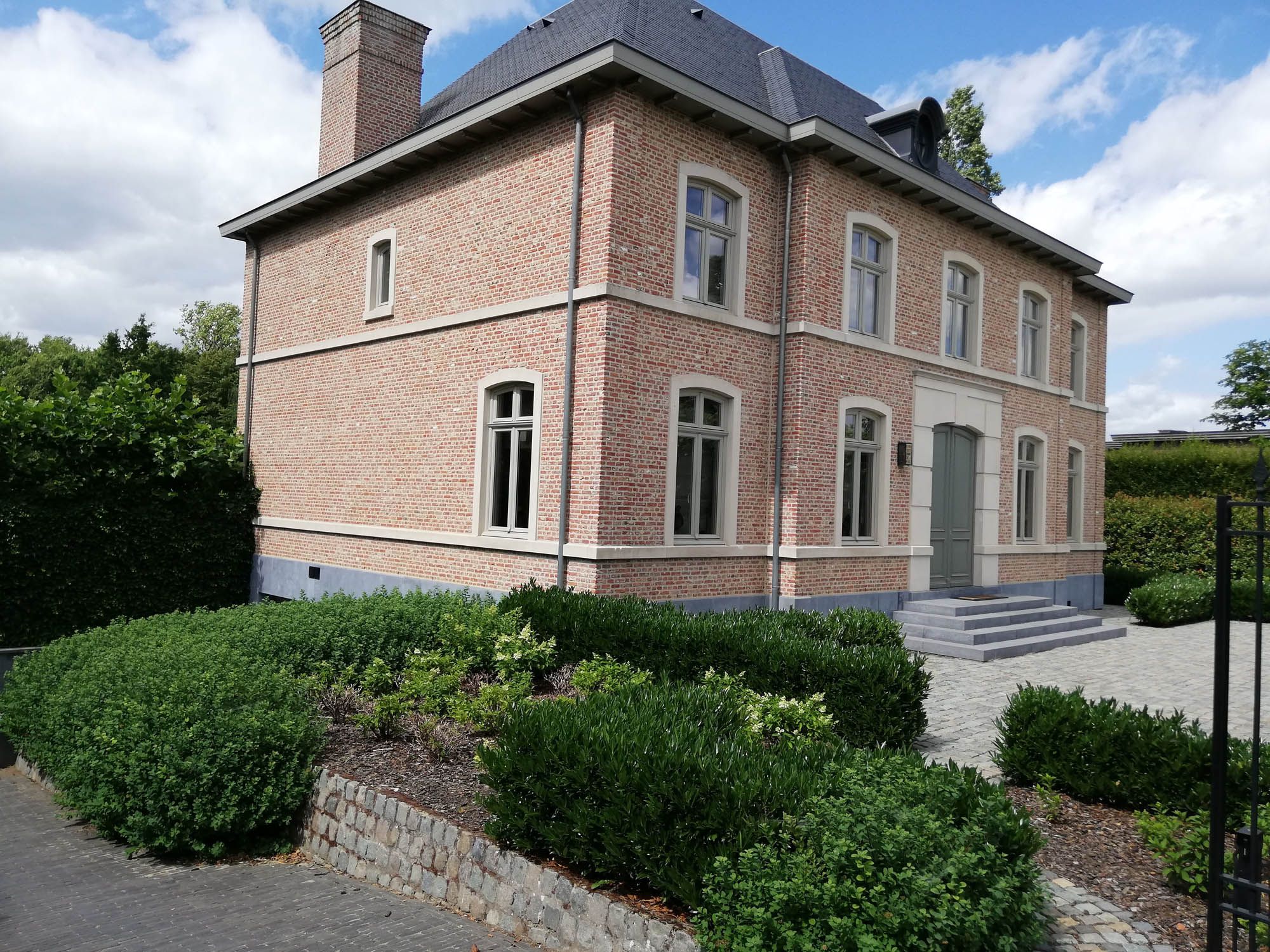 Herenhuis in baksteen met witte raamkozijnen na professionele glasbewassing