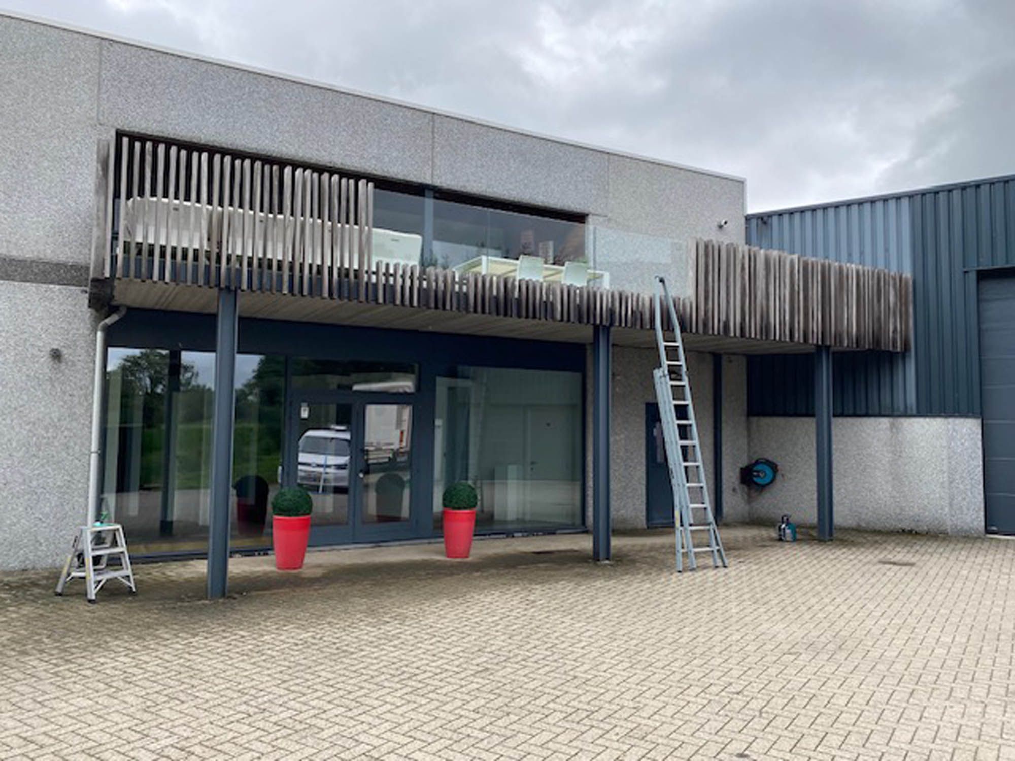 Bedrijfsgebouw met ladders opgesteld voor het reinigen van de bovenramen