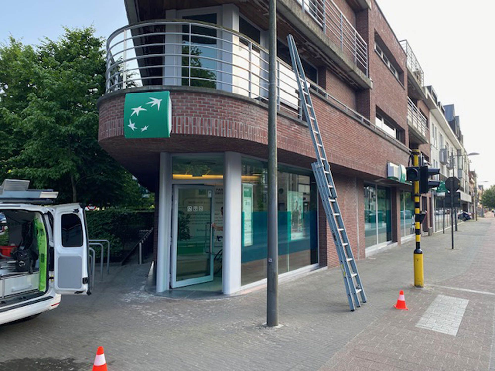Apotheek op de hoek met ladder en bestelwagen tijdens het ramen wassen