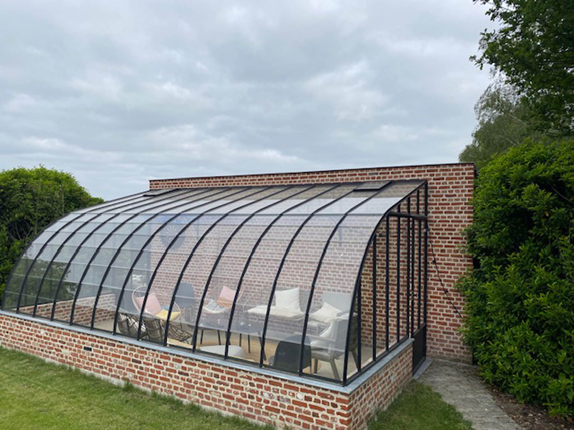Gebogen glazen veranda aan een woning met gereinigde ruiten
