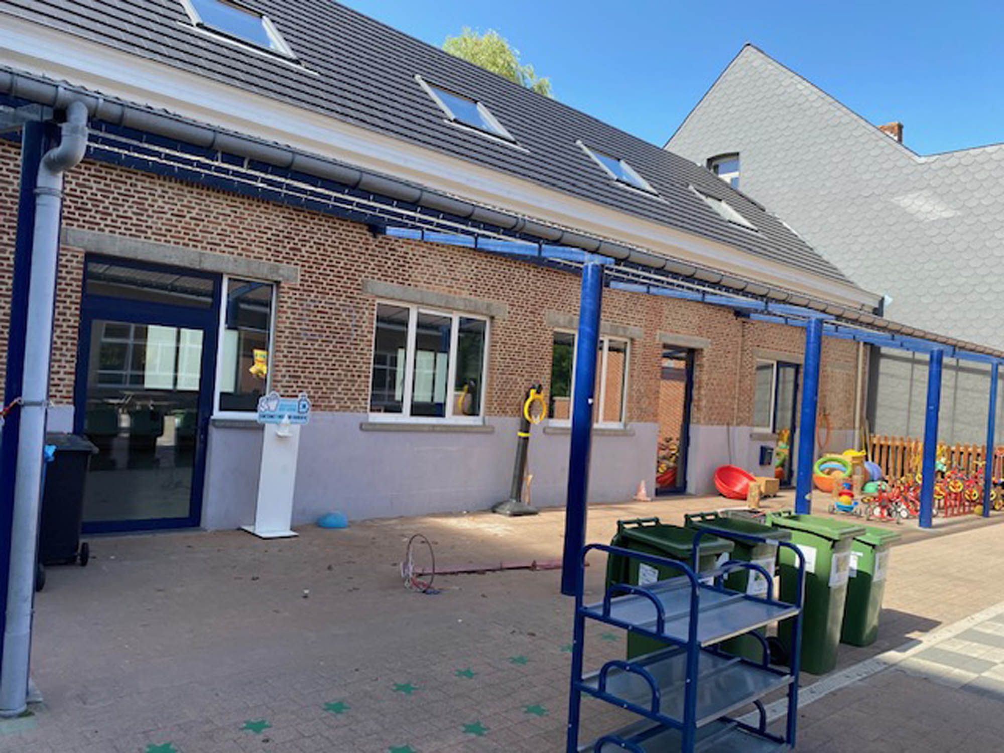 Speelplaats met overdekte gang en gereinigde klasramen