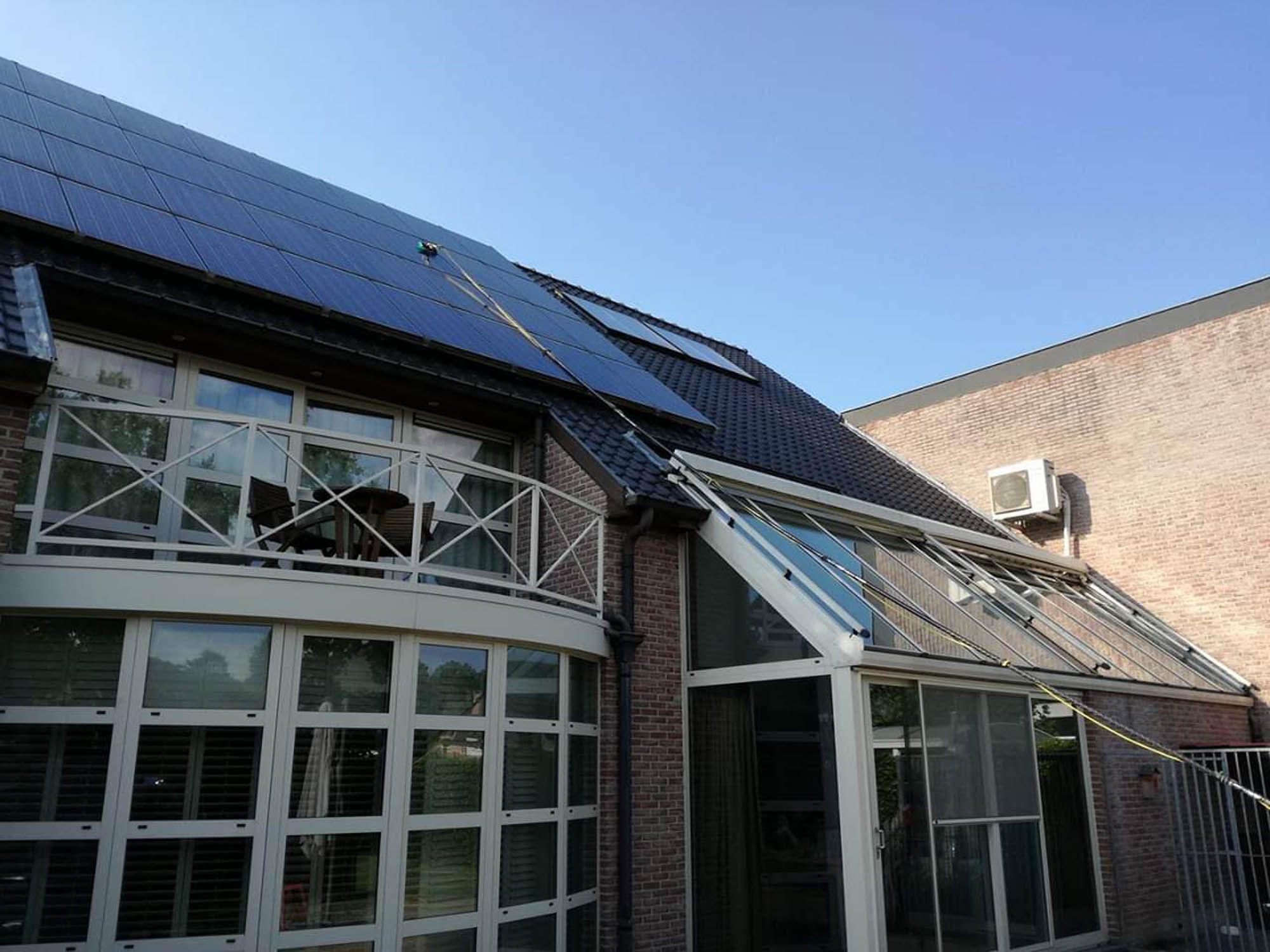 Bedrijfsgebouw met gebogen serre-aanbouw en zonnepanelen na reiniging