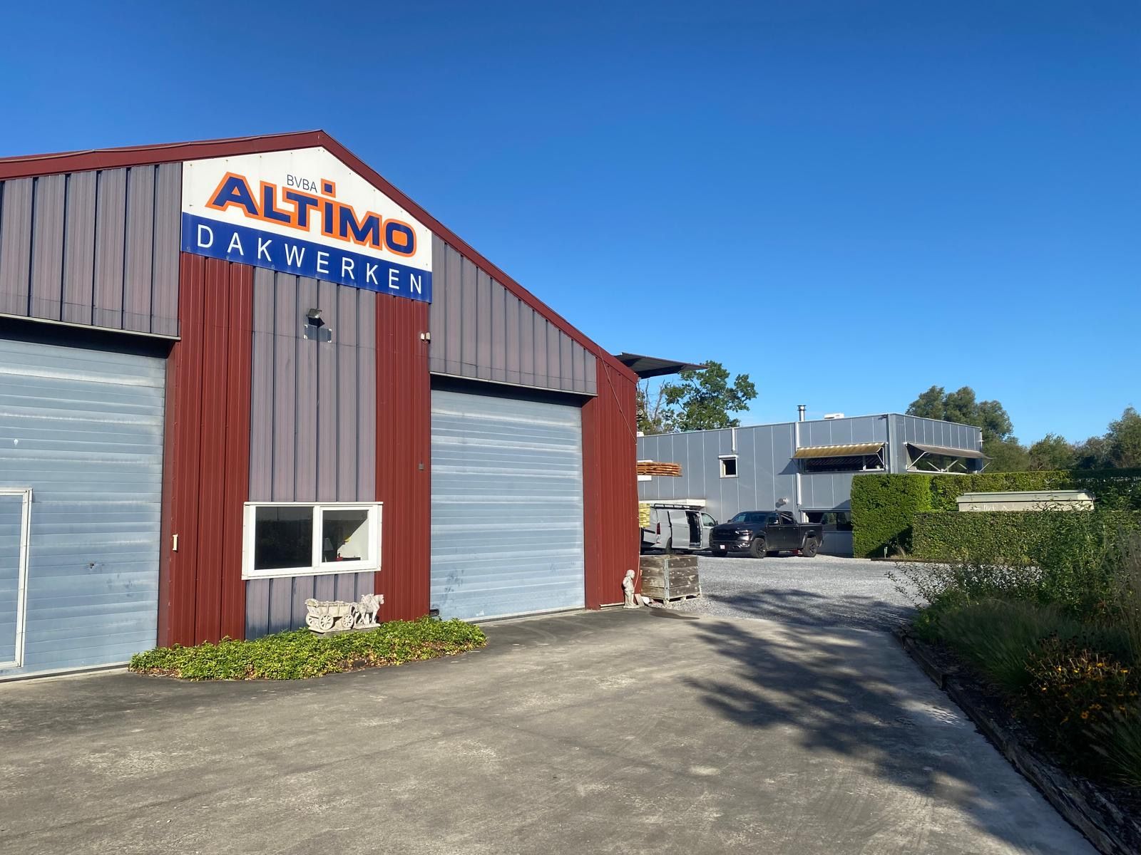 Loods van Altimo Dakwerken in Molenstede met het kantoorgebouw in aluminium gevelbekleding op de achtergrond